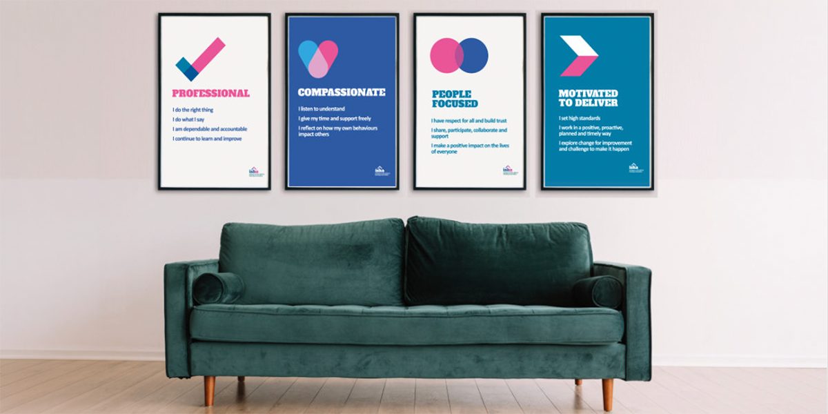 ISHA's four values as posters on the wall behind a teal sofa.
