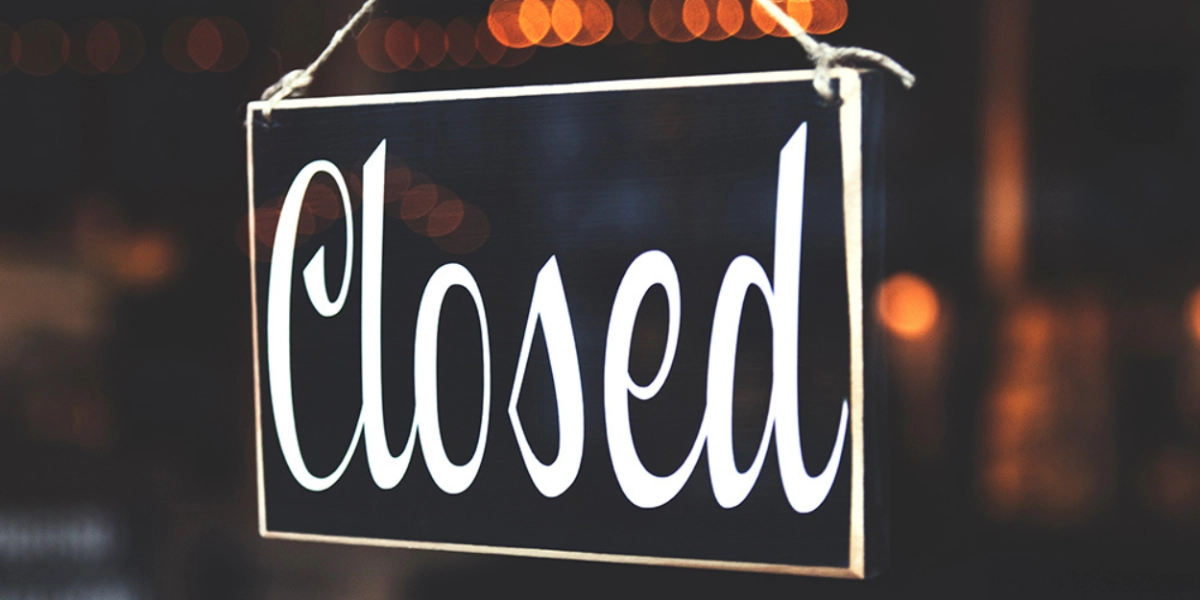 A closed sign hanging in a window.